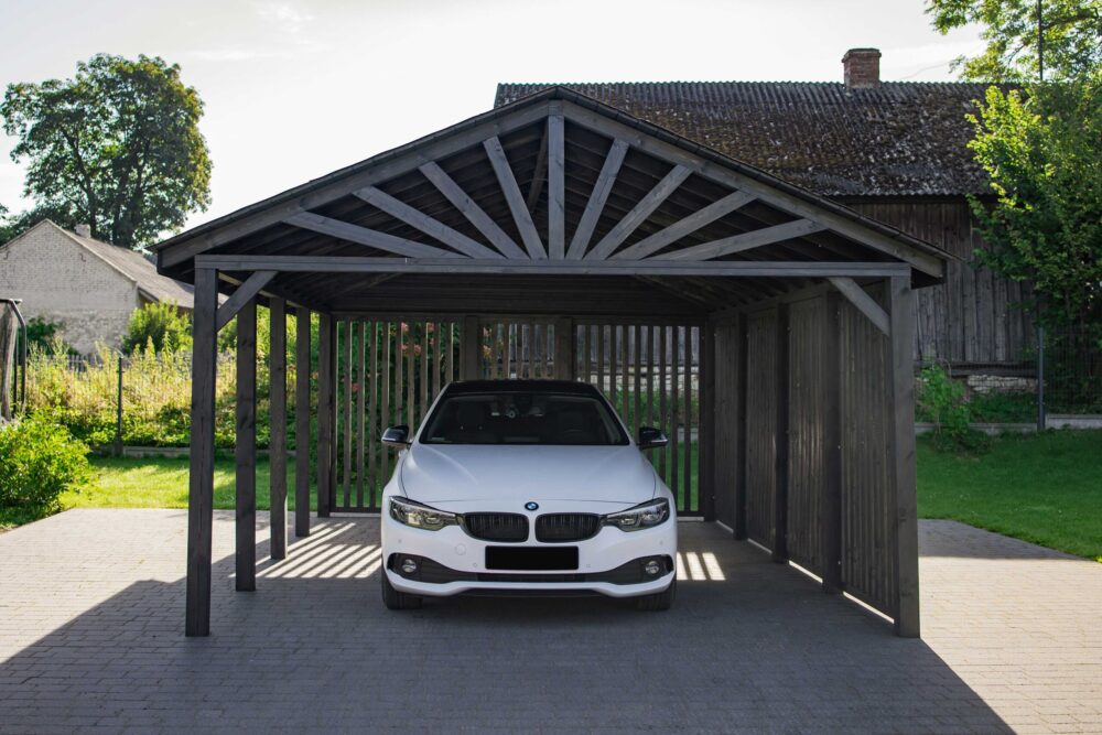 Auto marki BMW zaparkowane w car porcie wykonanym z drewna