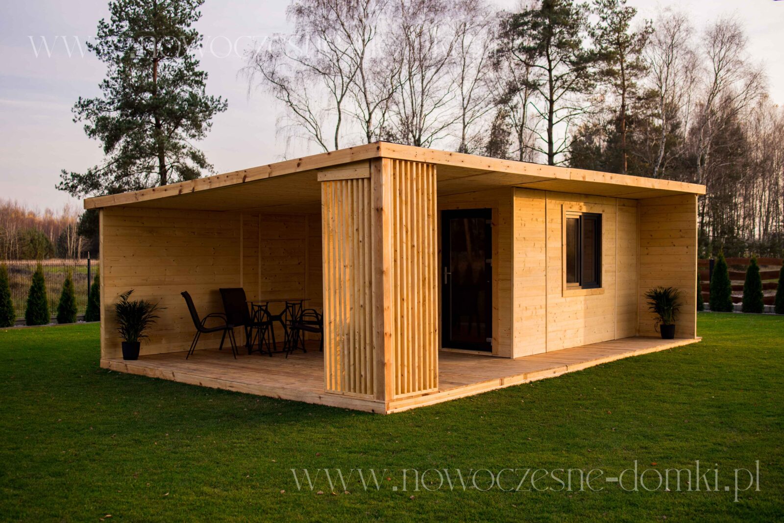Dřevěný letní dům s terasou na pozemku - Malebný letní dům zhotovený z dřeva s prostornou terasou.
