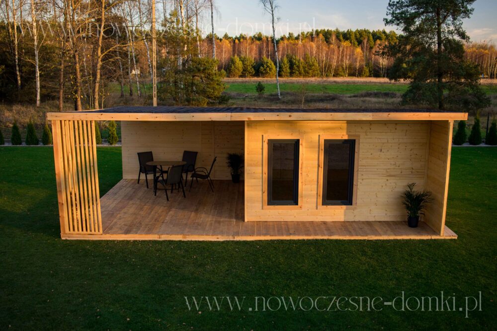 Drewniany domek ogrodowy z tarasem i szybami - Urokliwy domek letniskowy, wykonany z drewna, z przestronnym tarasem i eleganckimi szybami.