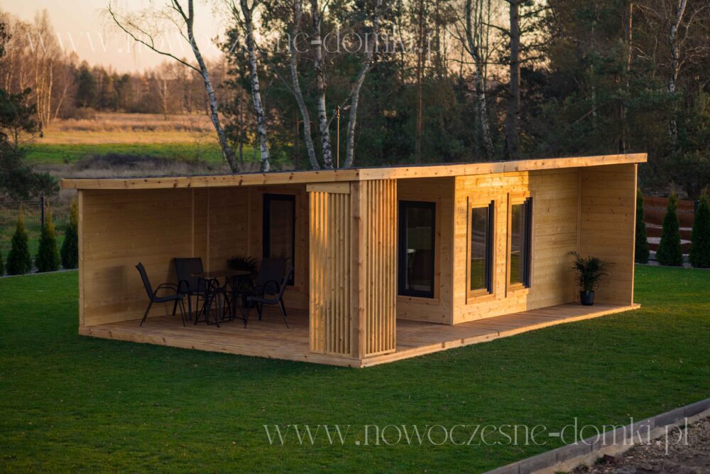 Prosklený dřevěný zahradní domek s terasou - Malebný letní domek, vyrobený z dřeva, s prostornou terasou a prosklenými okny.