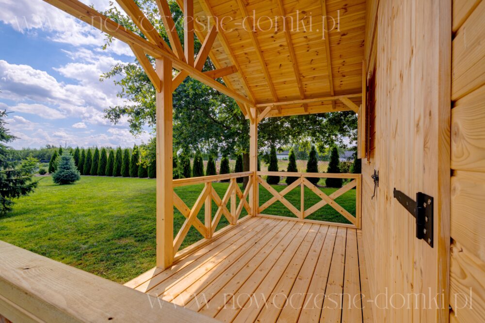Przestronny taras drewnianego domku na działkę - harmonijne połączenie natury i przestrzeni.