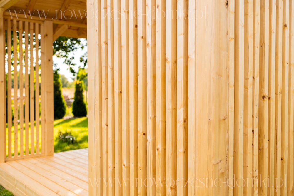 Solidny taras z drewnianymi barierkami - trwałość i estetyka w letniskowym domku.