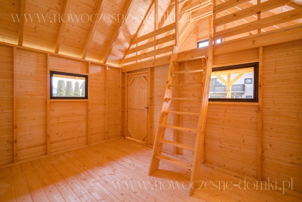 Starannie wykończone wnętrze domku drewnianego z okiennicami i drewnianymi schodami