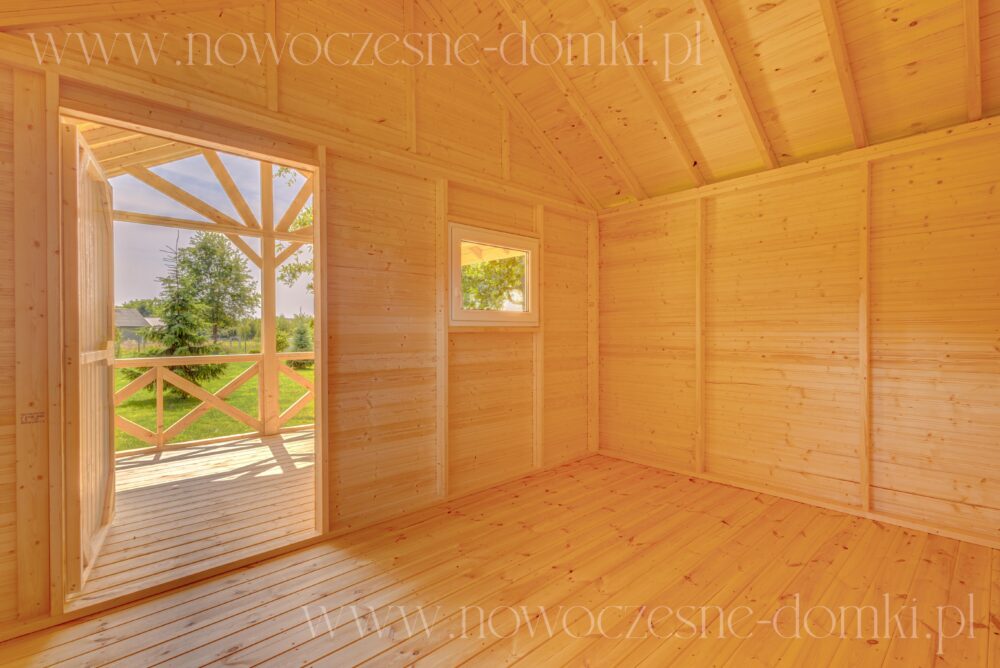 Wnętrze drewnianego domku na działkę z widokiem na taras - Połączenie przytulności i natury w letnim azylu.