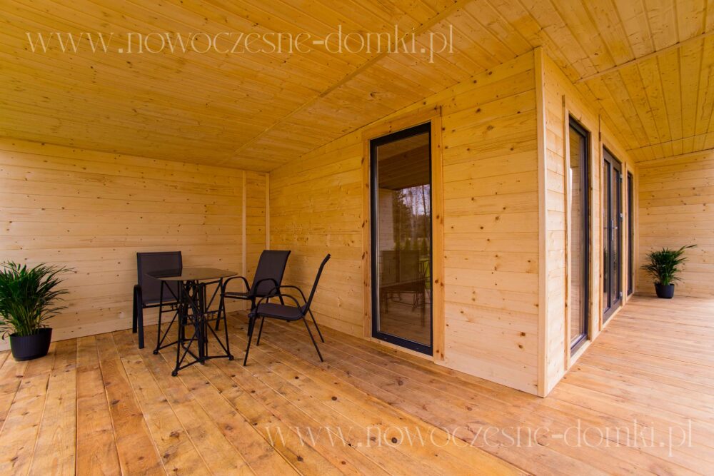 Przestronny taras drewnianej altany ogrodowej - idealne miejsce na wypoczynek na świeżym powietrzu.