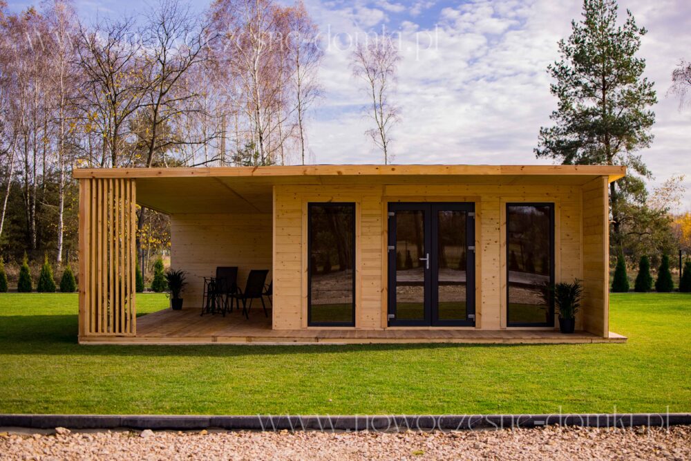 Starannie wykonany drewniany domek ogrodowy z tarasem i szklanymi elementami.