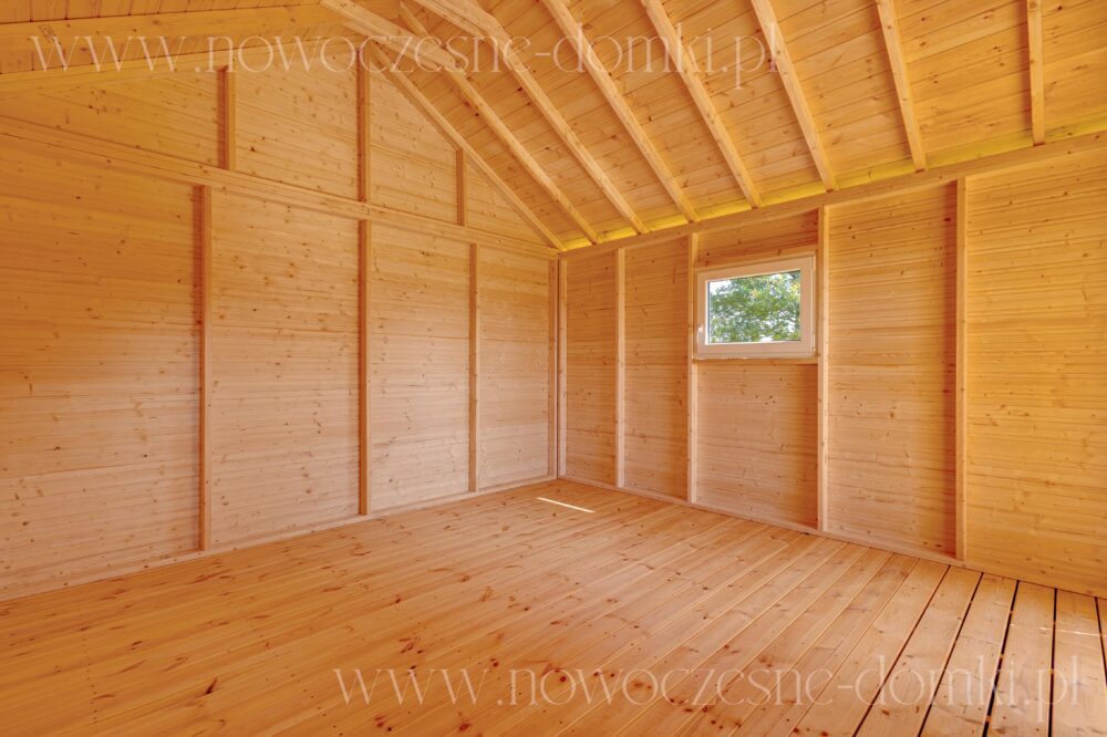 Wnętrze drewnianego domku letniskowego na działkę ogrodową - harmonijny design w naturalnym otoczeniu.