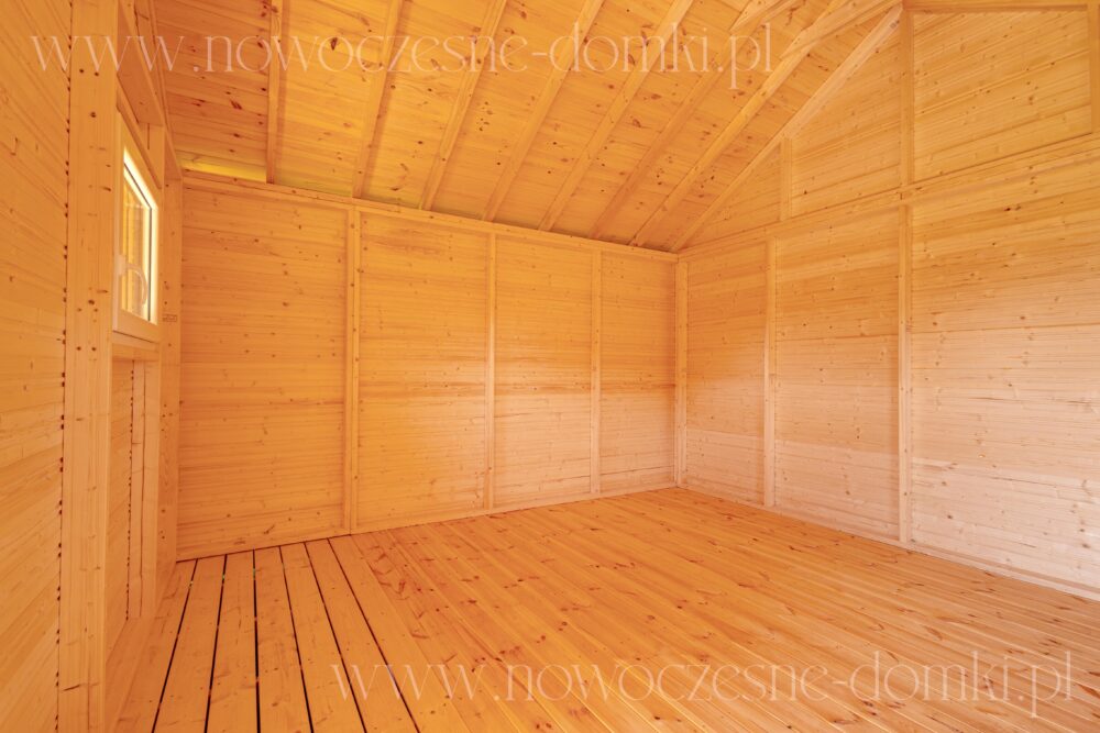 Wnętrze drewnianego domku na działce - Estetyczny design zapewniający harmonię z ogrodem.